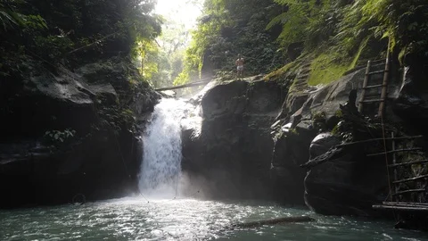 Fearless man jumps from a tall waterfall in the jungle, Extreme summer adventure Stock Footage 126101075