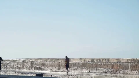 Fearless man walks along the beach and big wave falls on it. Stock Footage 72486862