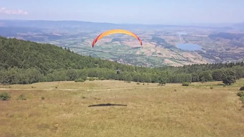 Fearless paraglider under a vibrant parachute takes a daring leap. Witness Stock Footage 252164875