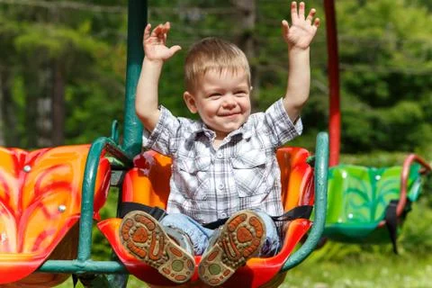 Fearless two-years-old boy riding on carousel Stock Photos