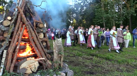 Feast of John parade and big log stacked burning fire in meadow Stock Footage 43472861