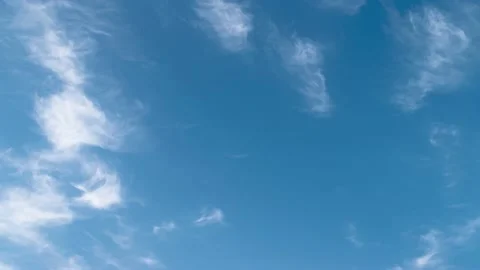 Feather clouds move across the blue sky during the day Stock Footage