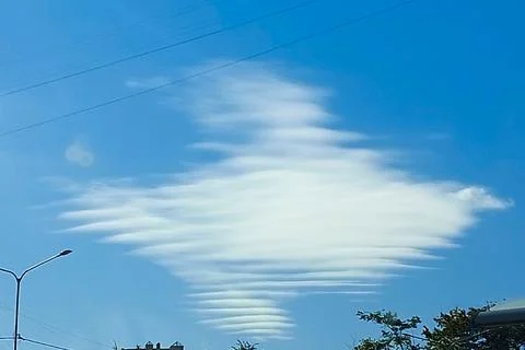 Feather clouds of unusual shape in the blue sky on a clear autumn day. Stock Photos