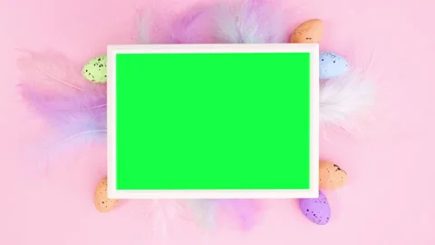 Feathers and Easter eggs appear around frame with green screen. Stop motion Stock Footage 148780267