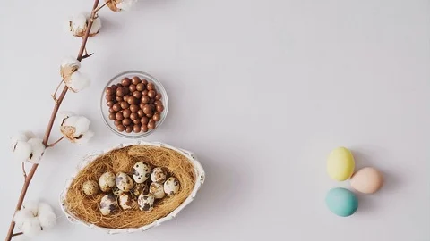 Feathers falling on colorful Easter eggs in nest and spring flowers on bright Stock-Footage 124382268