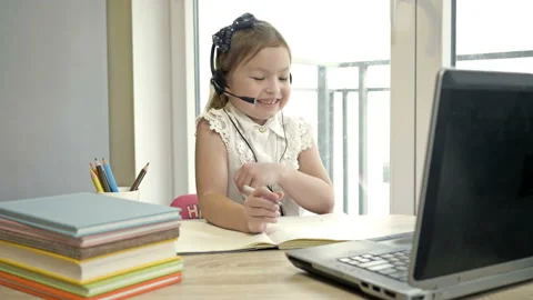 Features of distance learning. Online lesson. Little girl communicates with a Stock Footage 144178621
