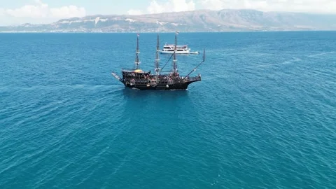 Featuring crystal-clear turquoise waters, a pebble beach, a pirate-style ship Stock Footage 329329615