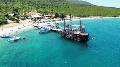Featuring crystal-clear turquoise waters, a pebble beach, a pirate-style ship Stock Footage 329386951