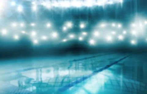 Featuring empty tiled pool with floating lane dividers, reflecting stadium 스톡 사진