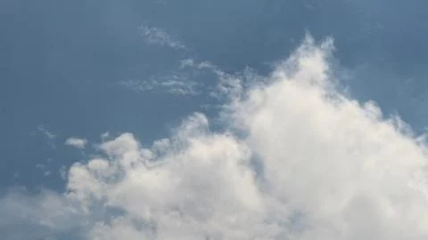 Featuring fluffy, bright clouds contrasted against a serene blue sky, the ima Foto stock