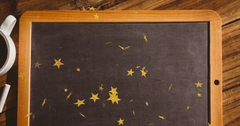 Featuring framed chalkboard lying flat on tabletop, with gold star confetti, Stock Photos