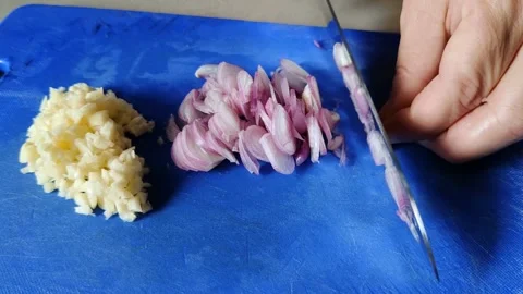 Featuring hands finely chopping onions and garlic Video stock 304065176