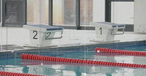 Featuring starting block number 2 on deck at swimming pool with red lane Stock Photos