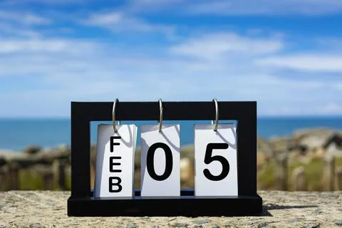 Feb 05 calendar date text on wooden frame with blurred background of ocean Stock Photos