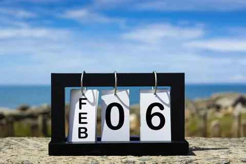Feb 06 calendar date text on wooden frame with blurred background of ocean Stock Photos