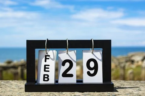 Feb 29 calendar date text on wooden frame with blurred background of ocean Stock Photos