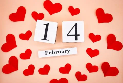 February 14 calendar date surrounded by red hearts on beige background Stock Photos