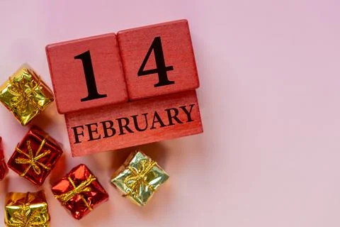 February 14. Valentine's Day composition with a wooden calendar and gift  Stock Photos