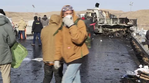 Federal agents stand off against crowds of protestors at the Dakota Access Vídeo Stock 75701410