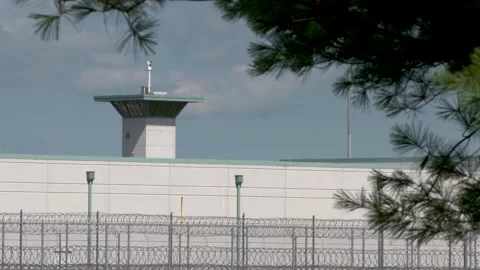 Federal Prison Wall and Tower with Barbed Wire Fence Stock Footage 147954191