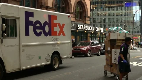 FedEx delivery man pulling dolly packages to truck Astor Place Manhattan NYC Stock Footage 106972519