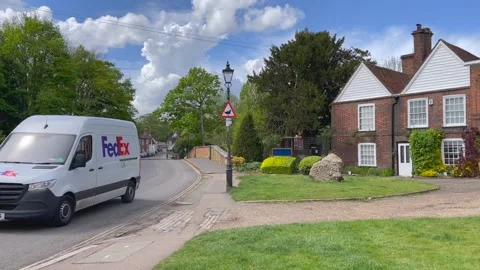A FedEx delivery van drives through a scenic street 動画素材 154099749