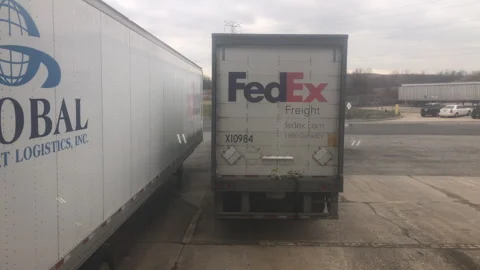 Fedex Trailer backs in to loading dock at distribution facility Stock Footage 264116408