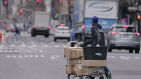 Fedex worker with face mask doing its delivery on 7th avenue Stock Footage 128823103