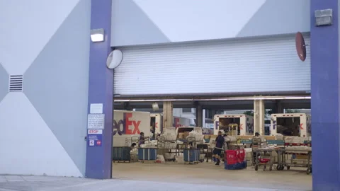 Fedex workers loading trucks at warehouse distribution center shot in 6k blac Stock Footage 131347397