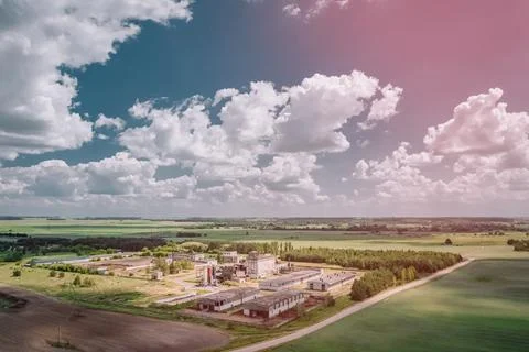 Feed mill in collective farm fields under picturesque sky with cumulus clouds Stock Photos