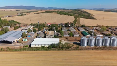 Feed silos and barns beside fields in rural Pásztó, Hungary, aerial view Stock Footage 345995489