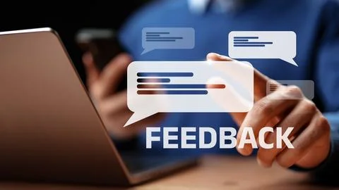 Feedback being given on a laptop while a person uses a smartphone in a Stock Photos