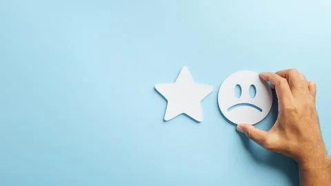 Feedback concept shows negative customer review as hand chooses unhappy fac.. Stock Photos