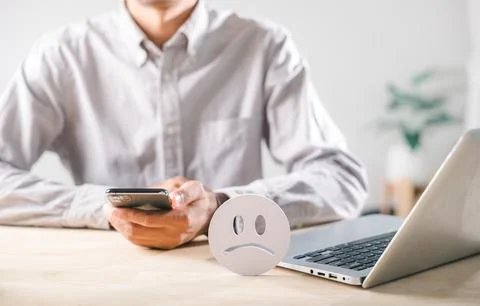 Feedback icon displays negative customer satisfaction, person uses phone an.. Stock Photos