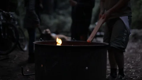 Feeding a campfire in a fire pit Stock Footage 91276143