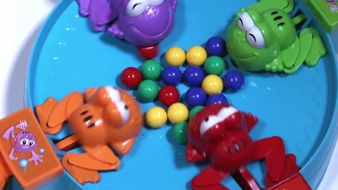 Feeding of four hungry plastic frogs with colored balls. Child game. Video stock 100178274