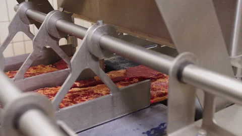 Feeding large pieces of meat into automatic cutter on conveyor belt Stock Footage 205489719