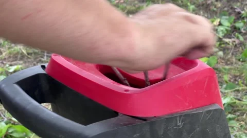 Feeding thick branch into a red garden wood chipper shredder Stock Footage 338416109