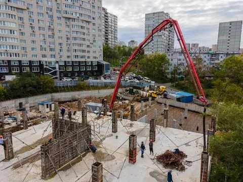 Feeding the working mixture of concrete to the construction site with a concrete Stock Photos