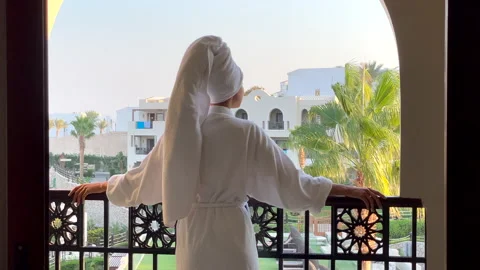Feel the class. Rear view of young woman in bathrobe admiring the view from the Stock Footage 151608905