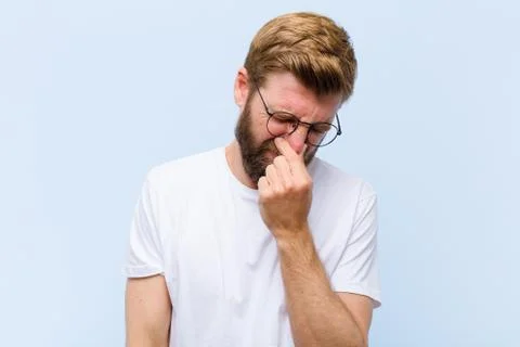 Feeling disgusted, holding nose to avoid smelling a foul and unpleasant stenc Stock Photos