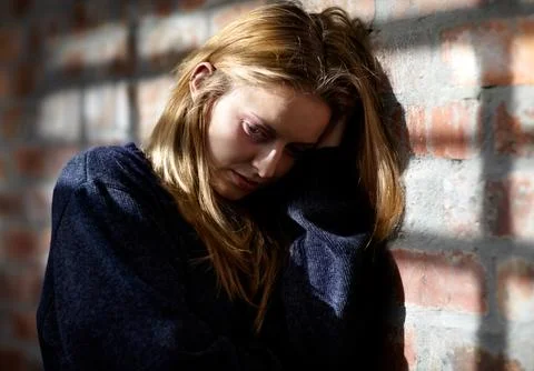 Feeling hopeless...Abused young woman with her hand in her hair. Stock Photos