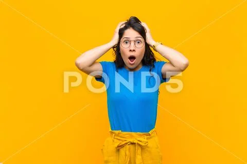 Feeling horrified and shocked, raising hands to head and panicking at a mista Stock Photos