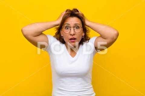 Feeling horrified and shocked, raising hands to head and panicking at a mista Stock Photos