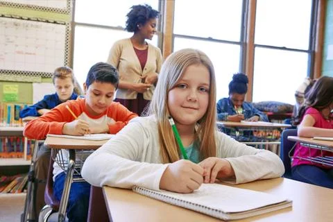 Feeling positive about her test. a young girl sitting in class with her teacher Stock Photos