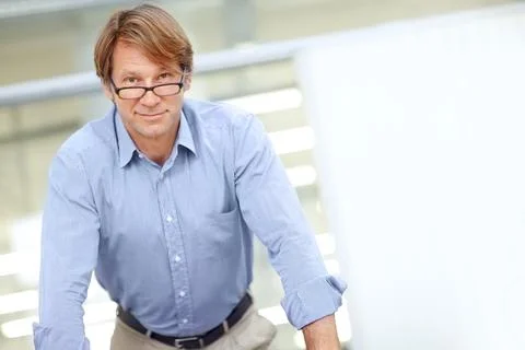 Feeling positive about work. Intelligent businessman in an office wearing Stock Photos
