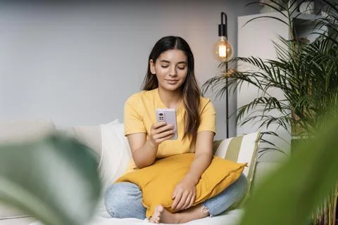 Feeling safe. Attractive multi-ethnic women 25s relaxed at home on couch Stock Photos