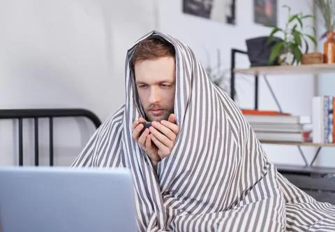 Feeling sick and work concept - man with laptop at home Stock-Fotos