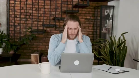 Feeling stressed. Frustrated handsome young man gets headache and irritation in Video stock 196467589