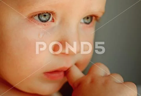 Feeling weepy. Baby with tear rolling down his cheek. Little boy child with sad Stock Photos